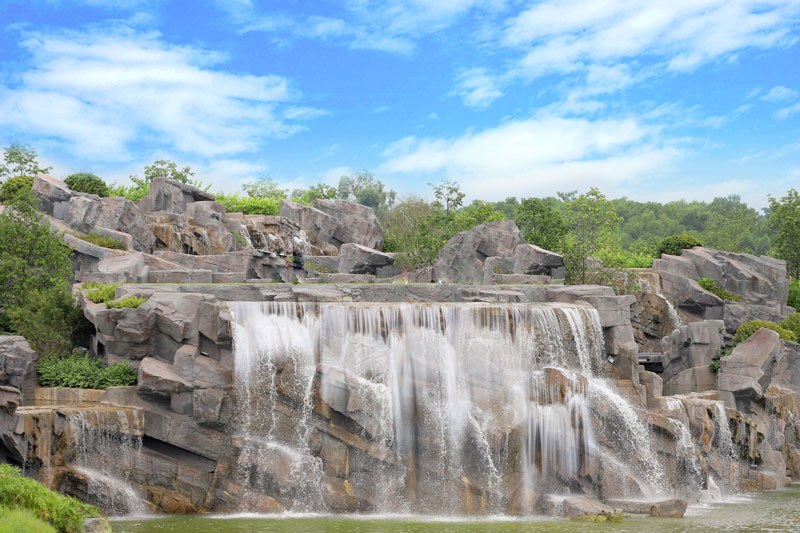 Great Falls Park over rocks with trees and blue skyDescription automatically generated